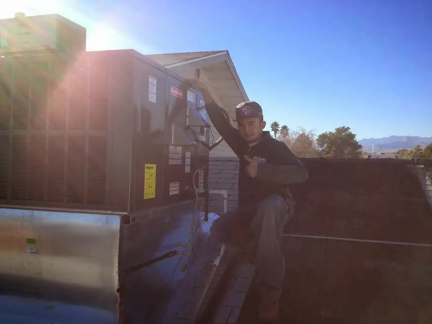 HVAC technician performing Boiler Repair on a rooftop unit in Peoria